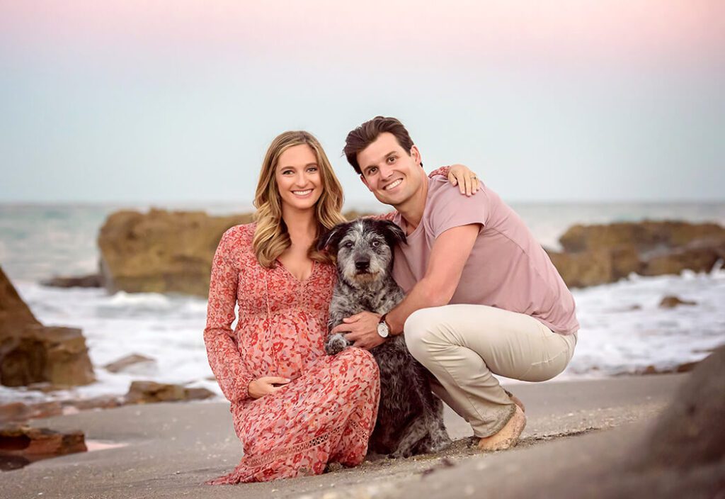 Erika, Scott, and their fur baby Skylar enjoying a family moment against the backdrop of Palm Beach County's stunning coastline.