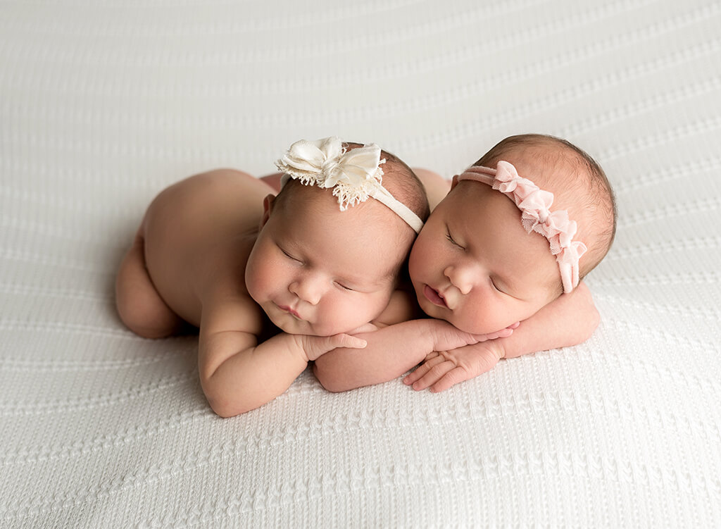 Beautiful infant Photography: baby girl twins posing on a white blanket at a newborn photography studio in Jupiter Florida