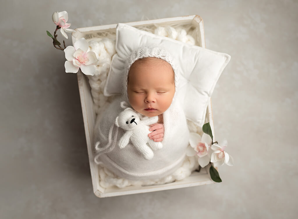 Luxury infant Photography: baby girl posing with teddy in a White box during a session at a newborn photography studio in Martin County Florida