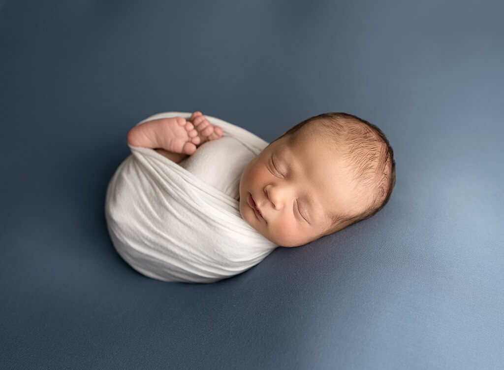 Luxury infant Photography: baby boy posing on a blue blanket during a session at a newborn photography studio in Wellington Florida