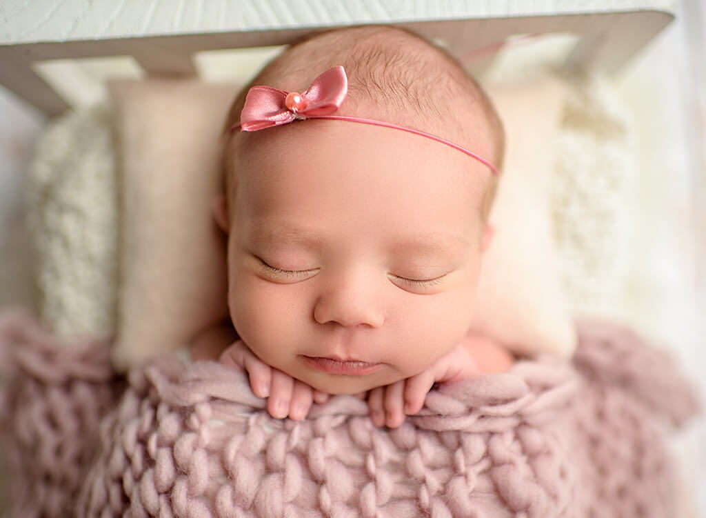 Sweet infant Photography: a baby girl sleeping in a photography prop bed at a newborn studio in Jupiter Florida