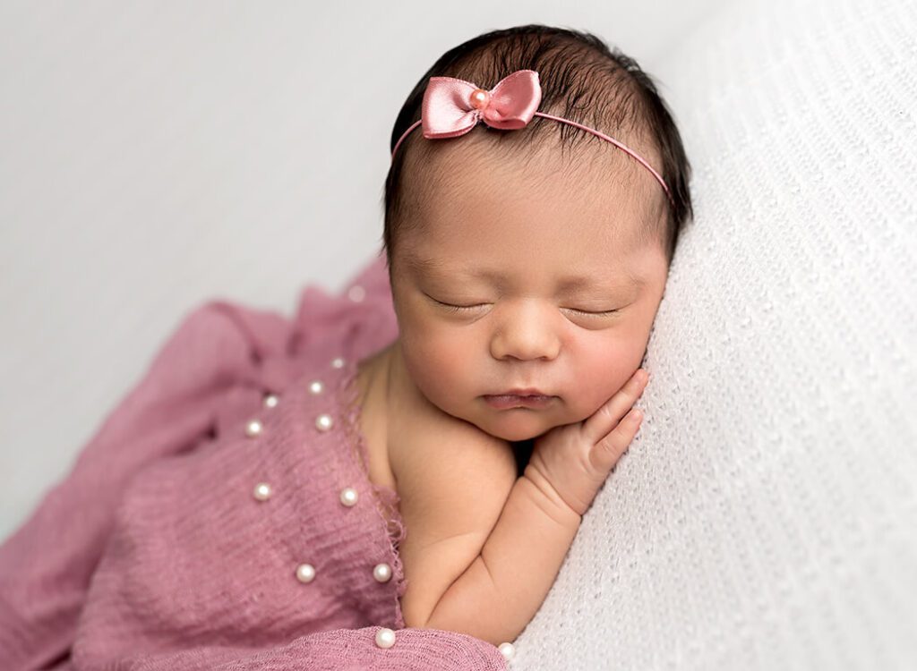 Closeup of newborn girl's features during a photography session.